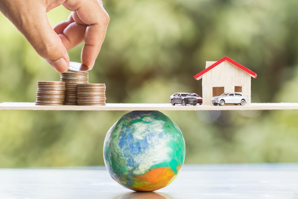 real-world-assets-1 Business real estate investment concept : Hands Dropshipping money coins on global wooden scales with balance.