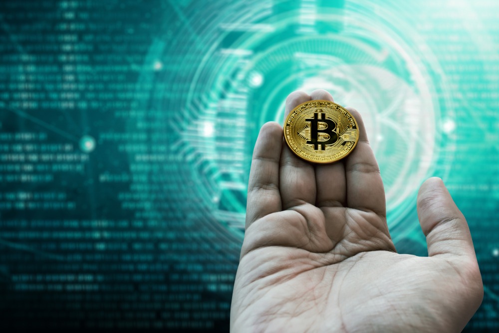 Hand holding golden bitcoin