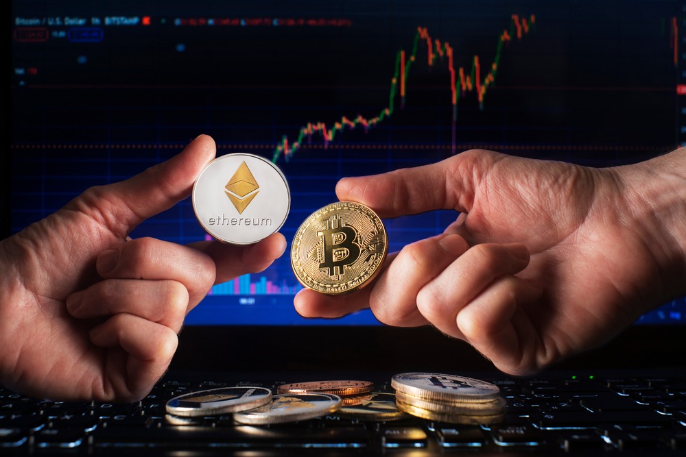 Business men holding bitcoin and ethereum coin whit computer trading chart background.
